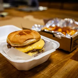 a cheeseburger in a styrofoam container