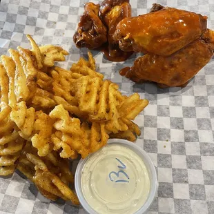 Buffalo wings with fries and blue cheese dipping sauce.