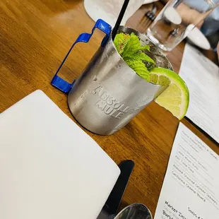 a drink in a silver cup with a lime wedge