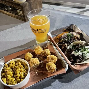 a tray of food and a glass of beer