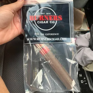 a hand holding a cigar