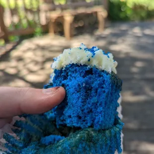 a hand holding a piece of cake