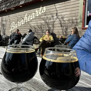 two glasses of beer on a wooden table