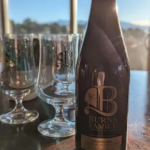 a bottle and glasses on a table