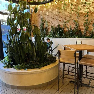 a table and chairs in front of a brick wall