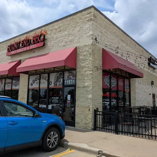 a blue car parked in front of the restaurant