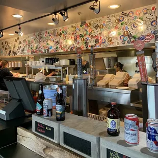a restaurant counter with a lot of stickers on the wall