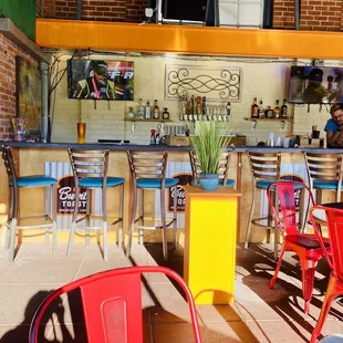 a colorful bar with chairs and tables
