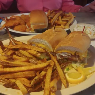 Fish sanwich in forgroubd and shrimp dinner in the background