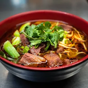 a bowl of soup with meat and vegetables