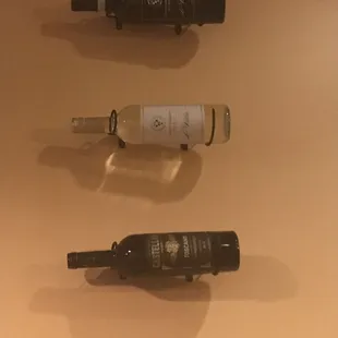 three empty wine bottles on a wall