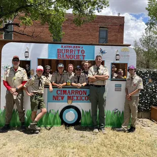 a group of scouts standing in front of a food truck