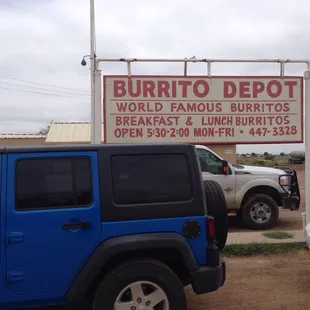 a blue jeep parked in front of a burrito depot