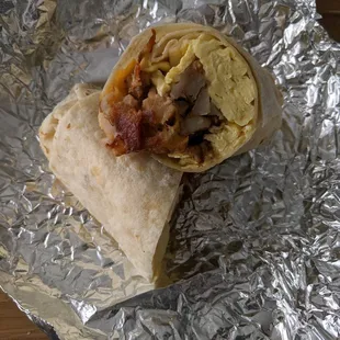 Man on a budget breakfast burrito with bacon, added beans.