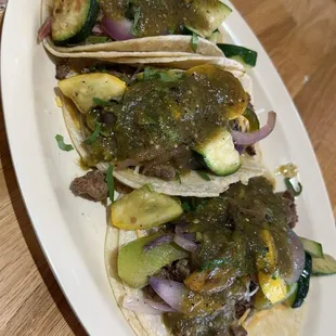 three tacos on a white plate