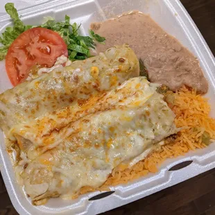 Beef enchiladas covered with tomatillo sauce and cheese, served with rice and refried beans.