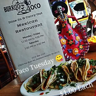 a plate of tacos and a sign for burrito loco
