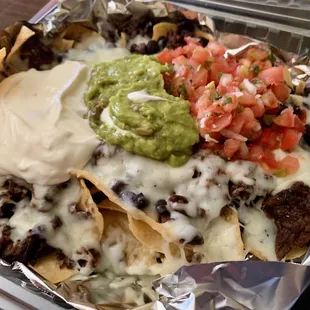 Super Beef Nachos - Tortilla Chips, Grilled Steak, Black Beans, Cheese, Pico de Gallo, Sour Cream, and Guacamole