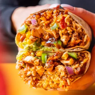 a hand holding a burrito