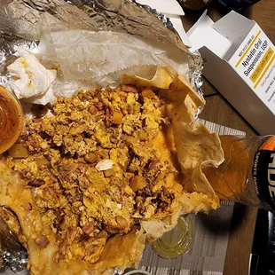 Breakfast burrito opened up showing larger pices of shell