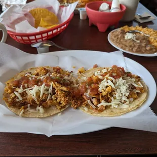 Two breakfast tacos with a side of rice and beans