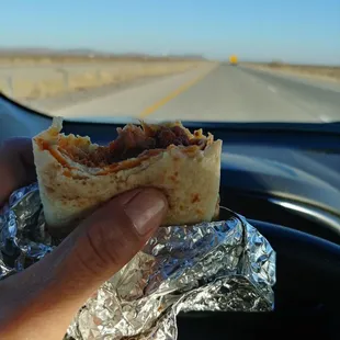 a hand holding a burrito