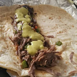 Adding some green salsa to my burrito.