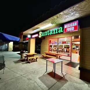 well lit store front with outdoor dining tables