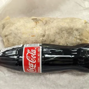 a bottle of coke and a burrito