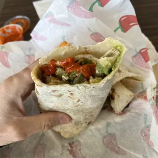 a hand holding a burrito