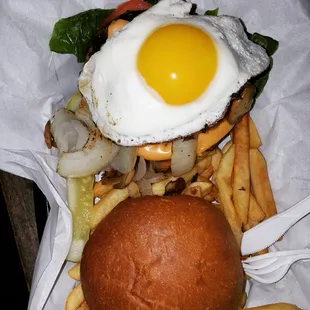 a burger with an egg and french fries