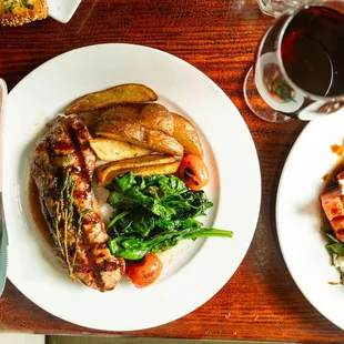 two plates of food and a glass of wine