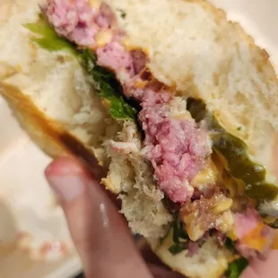 a hand holding a sandwich