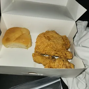 a piece of chicken and a roll