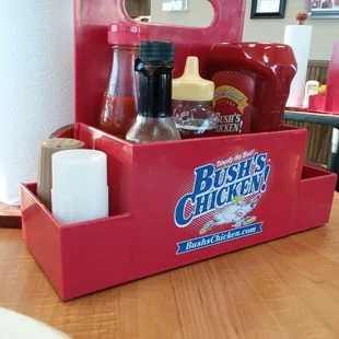 Each table has a caddy of condiments not excluding two different shades of hot sauce a little canister of their special seasoning.