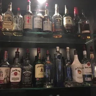 a shelf full of liquor bottles