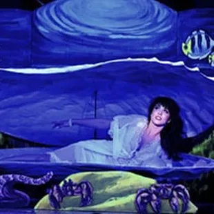 a woman in a white dress on a stage