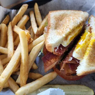 a bacon and egg sandwich with fries