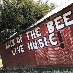 a red building with a sign that says back of the bee live music