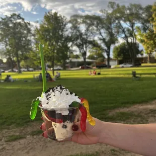 a hand holding a cup of ice cream