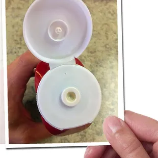 I took a picture of my ketchup bottle lid before making this picture of someone else holding the picture I took.