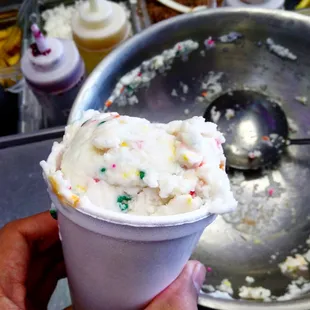 a person holding a cup of ice cream