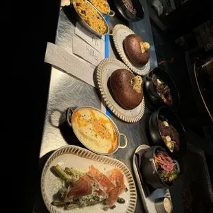 Serving station: Mac and cheese, cornbread with butter on top, potatoes, asparagus, and more!