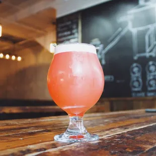 a glass of beer on a wooden table