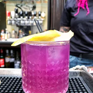 a purple drink with a lemon wedge