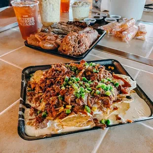a tray of nachos and a tray of fries