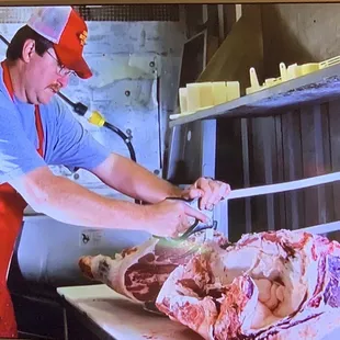 a man cutting meat on a cutting board