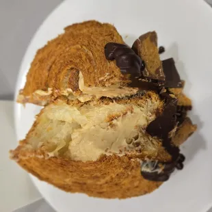 Peanutbutter chocolate croissant on a coffee saucer plate
