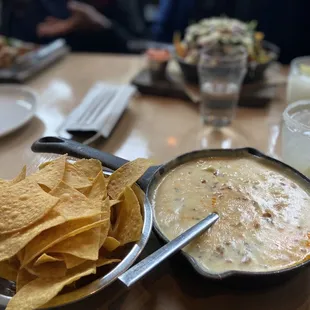 Happy Hour:  queso Blanco/chips Brisket nachos (back)  Tacos (back left)  Margarita on the rocks