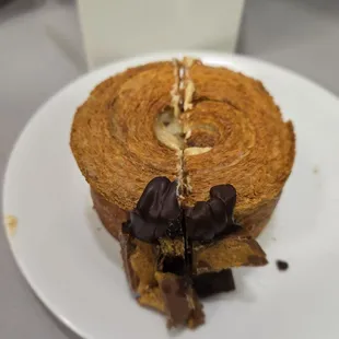 Peanutbutter chocolate croissant on a coffee saucer plate